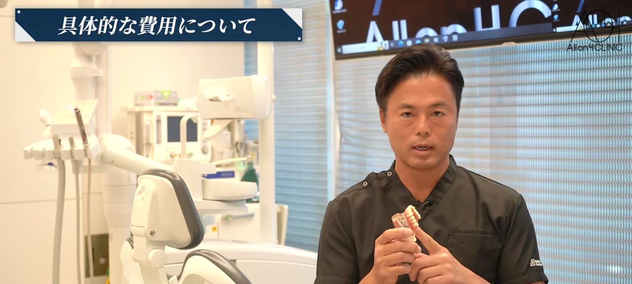最終補綴装置の模型を手に取り、歯の部分の種類を説明する総院長